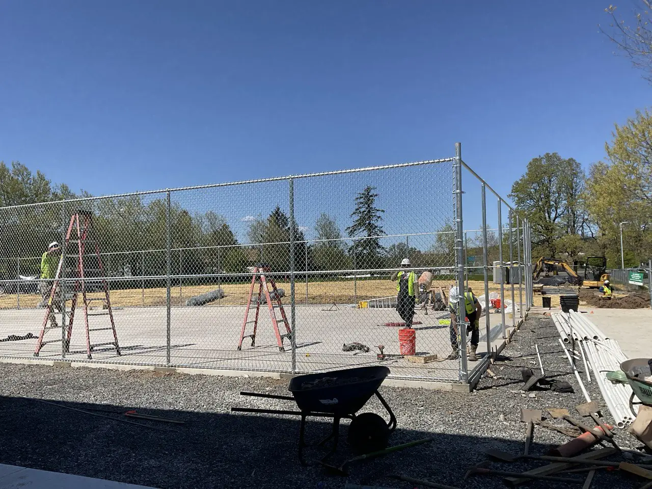 Installation crew working on a sports court fence project