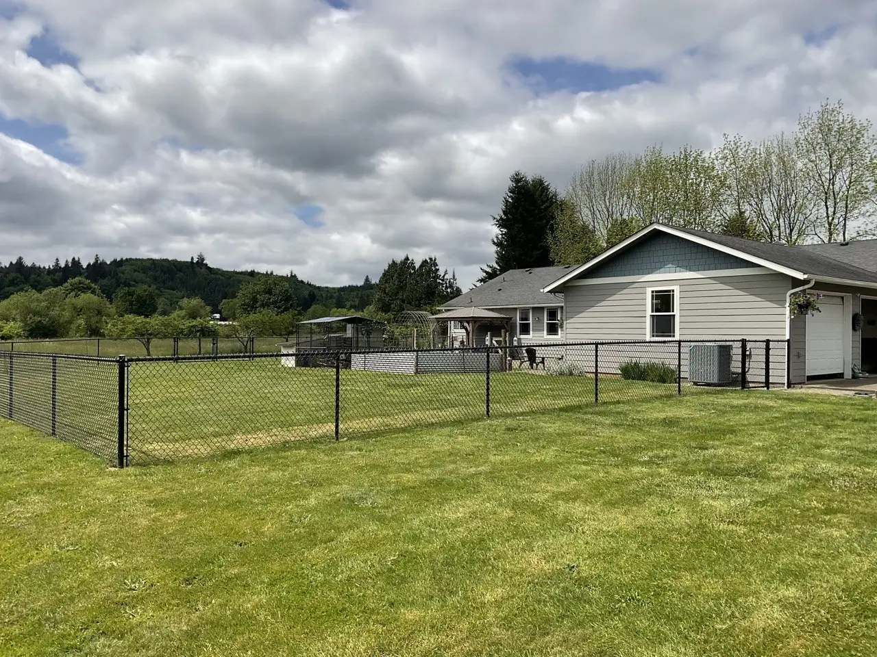 Black vinyl-coated chain link fence enclosing an acreage property