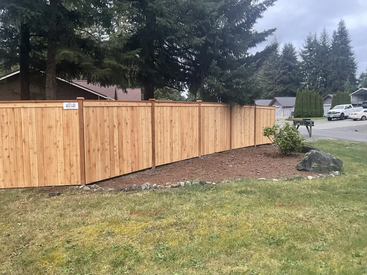 Capped cedar privacy fence with post caps on a residential corner lot in Western Washington